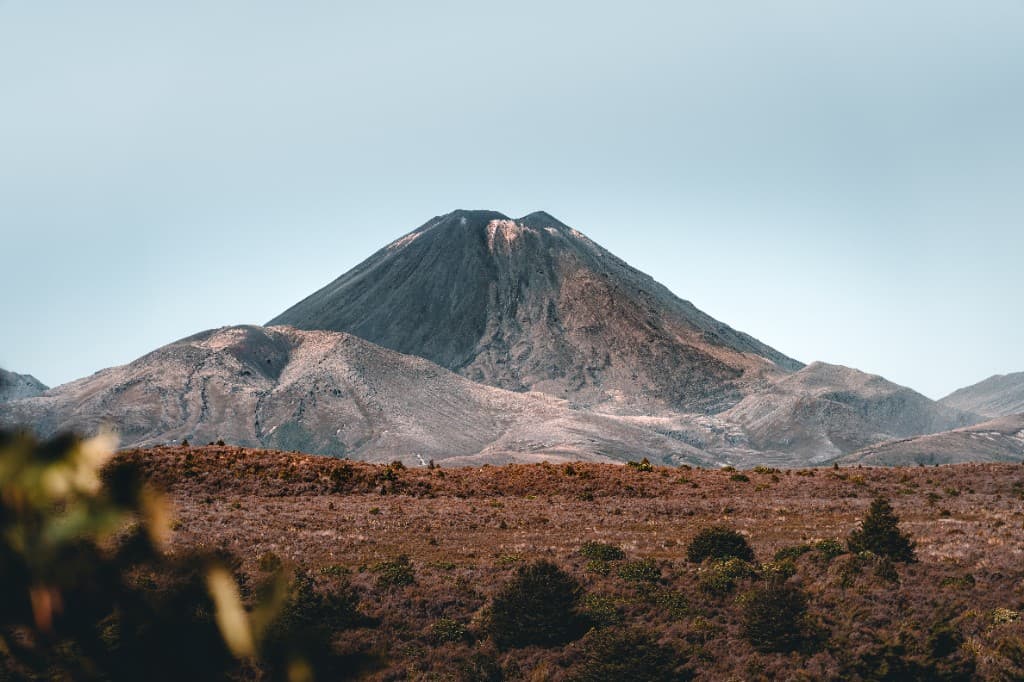 A symmetrical volcanic cone rising above a barren alpine landscape.